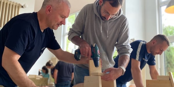 Das Bild zeigt eine Szene vom Nistkastenworkshop: Karsten Peterlein hilft beim Zusammenschrauben des Nistkastens.