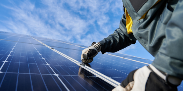 Ein*e Installateur*in richtet PV-Module ein.