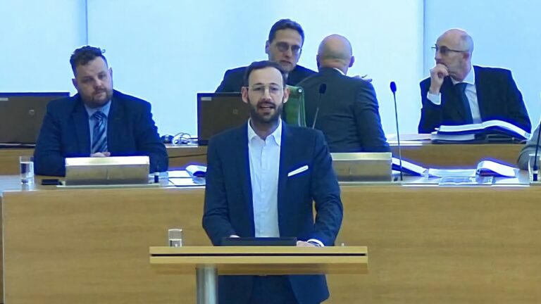 Auf dem Bild ist Daniel am Redepult im Sächsischen Landtag zu sehen.