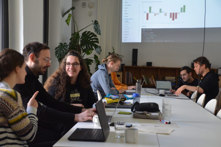 Daniel im Kreis der Workshopteilnehmenden. Ein aufgeklappter Laptop steht vor ihm, auf dem er etwas schreibt.